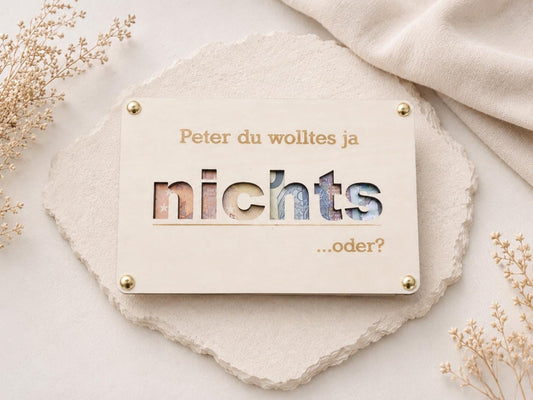 Kreative Geldverpackung aus Holz mit ausgeschnittenem Wort nichts und personalisiertem Namen.